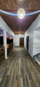 a room with a wooden floor and a ceiling with a chandelier at Meztli Beach House in La Manzanilla