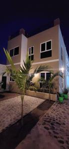 a house with a palm tree in front of it at Meztli Beach House in La Manzanilla
