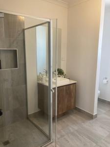a bathroom with a shower and a sink at Spacious Private 4BR Upper Floor Sleeps 8 Spa Free parking in Werribee +5 photos