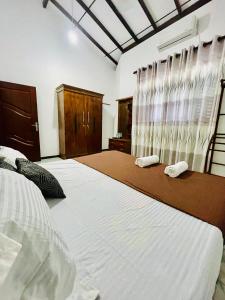 a bedroom with two beds with towels on them at Aamy Luxury Villa in Galle