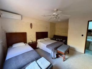 a bedroom with two beds and a ceiling fan at Casa Bugambilia Progreso #4 in Progreso