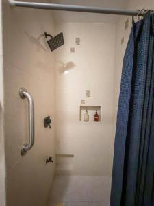 a bathroom with a shower with a blue shower curtain at Casa Bugambilia Progreso #4 in Progreso