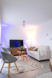 a living room with a white couch and a tv at Acogedora casa cerca del mar in San Pedro de la Paz