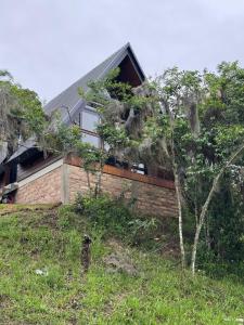 a house on a hill with trees in front of it at Refúgio do Morro - cabana 2 in Torres