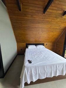 a bed in a room with a wooden ceiling at Refúgio do Morro - cabana 2 in Torres