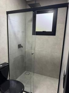 a shower with a glass door in a bathroom at Refúgio do Morro - cabana 2 in Torres +1 photo