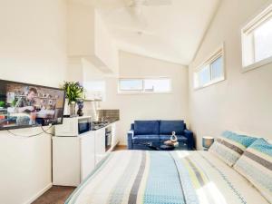 a bedroom with a large bed and a kitchen at McKillop Geelong by Gold Star Stays in Geelong