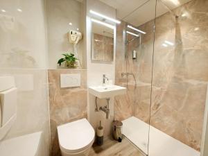 a bathroom with a toilet and a sink and a shower at Hotel Cardiff in Ostend