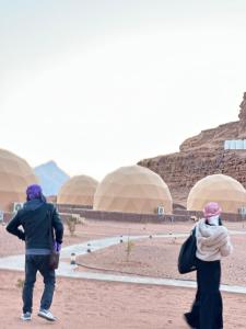 two people walking in front of a building at Jihad camp in Disah