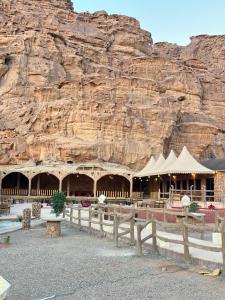 a building in front of a rock wall at Red sand tent in Disah