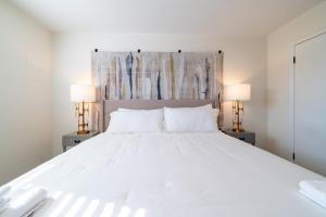 a bedroom with a large white bed with two lamps at Sojourn's Harborage 2 BR 1 BA in Norfolk