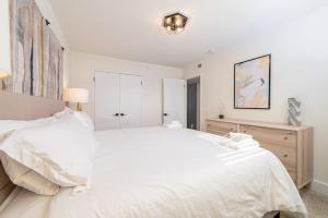 a white bedroom with a large bed and a dresser at Sojourn's Harborage 2 BR 1 BA in Norfolk
