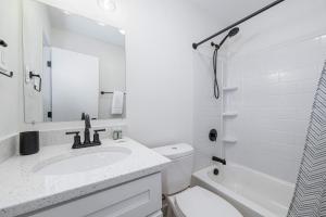 a white bathroom with a sink and a toilet at Sojourn's Harborage Pet-Friendly # 3 in Norfolk