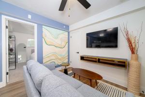 a living room with a couch and a tv on a wall at Sojourn's Harborage Pet-Friendly # 3 in Norfolk +5 photos