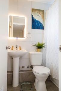 a bathroom with a toilet and a sink at Acogedora casa cerca del mar in San Pedro de la Paz