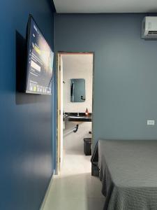 a room with a bed and a television on a wall at Hotel e Restaurante Santa Isabel in São Raimundo Nonato