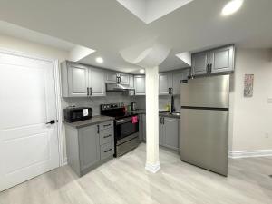 a kitchen with a stainless steel refrigerator and cabinets at Modern 2BR Suite Private Entrance Parking New in Woodstock +10 photos
