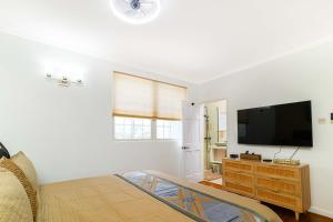 a bedroom with a bed and a flat screen tv at Paradise Haven Saint Lucia in Corinthe