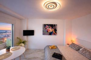 a living room with a bed and a painting on the wall at Romantic Sea View Studio with Jacuzzi in Alicante Center in Alicante