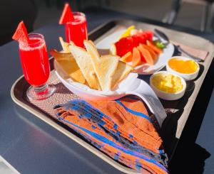 a tray of food with chips and fruit and a drink at Sun Top Grand in Ella