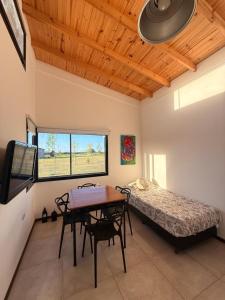a bedroom with a bed and a table and chairs at Almada - Casas de Campo in Baradero