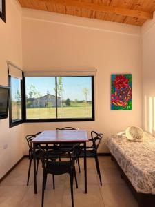 a dining room with a table and chairs and a bed at Almada - Casas de Campo in Baradero +30 photos