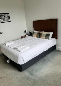 a bedroom with a large bed with white sheets at Amaroo Hotel Dubbo in Dubbo
