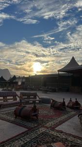 a group of benches sitting on a rug with the sun setting at Sunset mountain in Disah