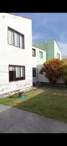 a white house with a tree in front of it at Dodig in Chincha