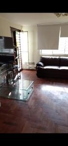 a living room with a couch and a glass table at Dodig in Chincha