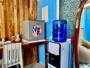 a kitchen with a refrigerator and a water cooler on a table at LADY GHAGHA ROOM RENTALs in San Vicente