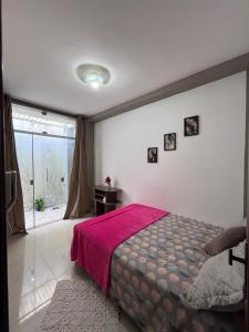 a bedroom with a bed with a pink blanket on it at Villa sonhos in Belém