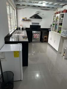 a kitchen with white cabinets and a white floor at Villablanca in Cuenca +21 photos