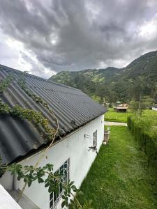 a white building with a black roof with mountains in the background at Villablanca in Cuenca