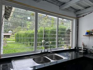 a kitchen with a sink and a large window at Villablanca in Cuenca