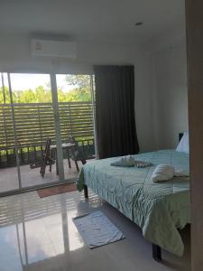 a bedroom with a bed and a view of a balcony at Katika Home 2 in Ban Khlong Haeng