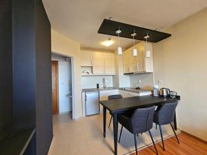 a kitchen and dining room with a black table and chairs at One-Bedroom Apartment with Balcony & Fast WiFi in Bansko