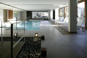 a swimming pool in a building with a lobby at Lo Chalet in Castione della Presolana