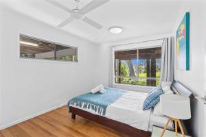 a bedroom with a bed and two windows at Surf Gums, Sleeps 9, Pet Friendly, Fully Renovated in Point Lookout