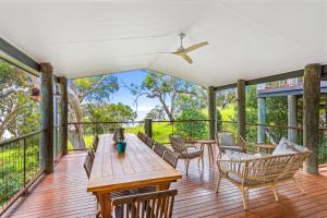 a deck with a wooden table and chairs at Surf Gums, Sleeps 9, Pet Friendly, Fully Renovated in Point Lookout