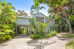 a house with a pivot door in the middle of trees at Surf Gums, Sleeps 9, Pet Friendly, Fully Renovated in Point Lookout
