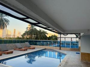 a swimming pool with lounge chairs and a building at Loft playa y mar in Cartagena de Indias
