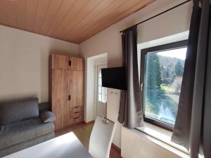 a living room with a large window and a couch at Lahnzauber Obernhof in Obernhof