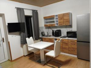 a kitchen with a table and chairs and a refrigerator at Lahnzauber Obernhof in Obernhof