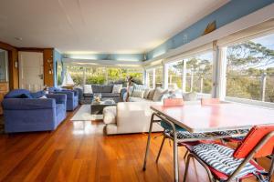 a living room with a couch and a table at The Shack - Beachside At Binalong in Binalong Bay