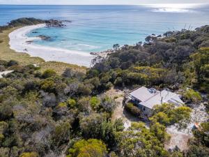 an aerial view of a house on a hill next to a beach at The Shack - Beachside At Binalong in Binalong Bay