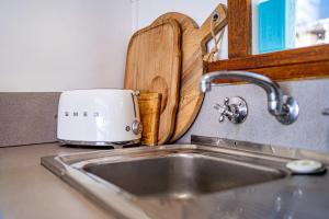 a toaster sitting on top of a kitchen sink at The Shack - Beachside At Binalong in Binalong Bay +47 photos