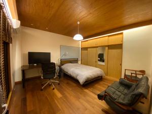 a bedroom with a bed and a desk and chair at Inn Azur in Yamatotakada