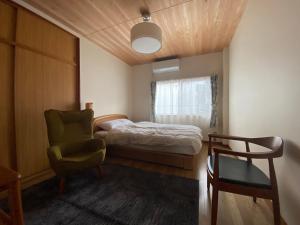 a small bedroom with a bed and a chair at Inn Azur in Yamatotakada
