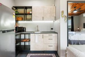 a kitchen with a sink and a bed in a room at Pukeko Guesthouse - Relax in Redcliffe in Redcliffe +10 photos